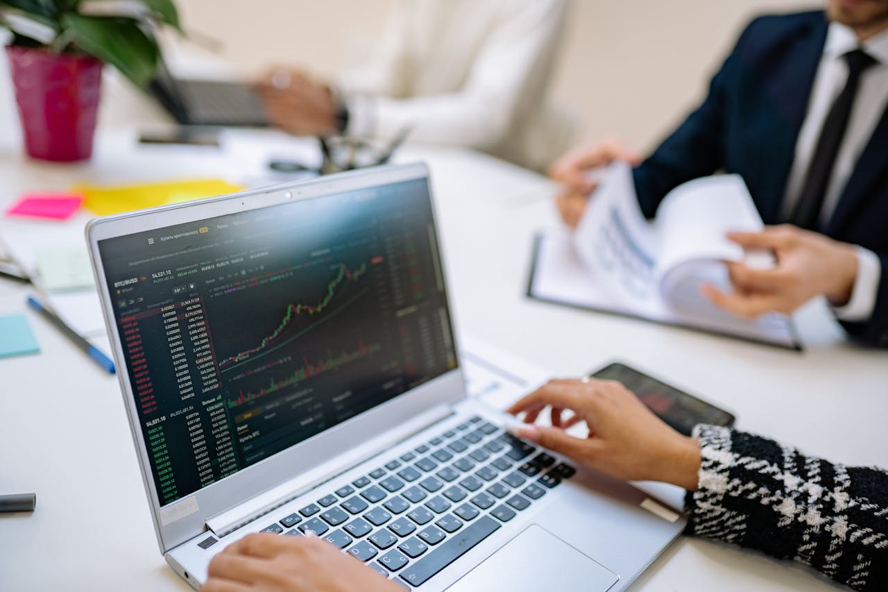 Business team analyzes cryptocurrency market trends using a laptop with graphs and data.